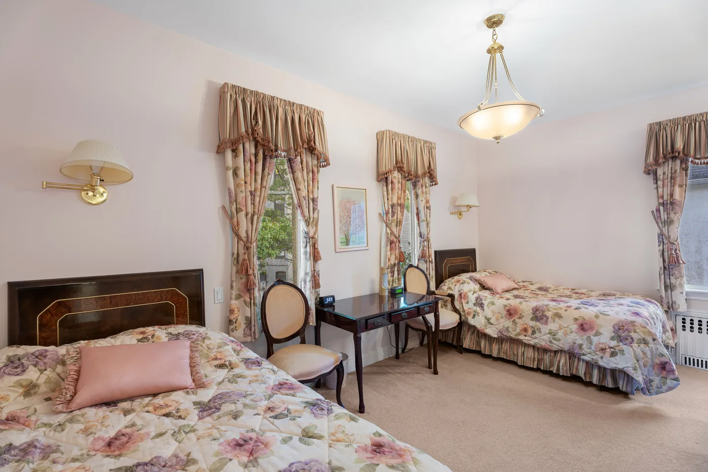 Floral bedroom with fireplace photographed for a New York City real estate listing.
